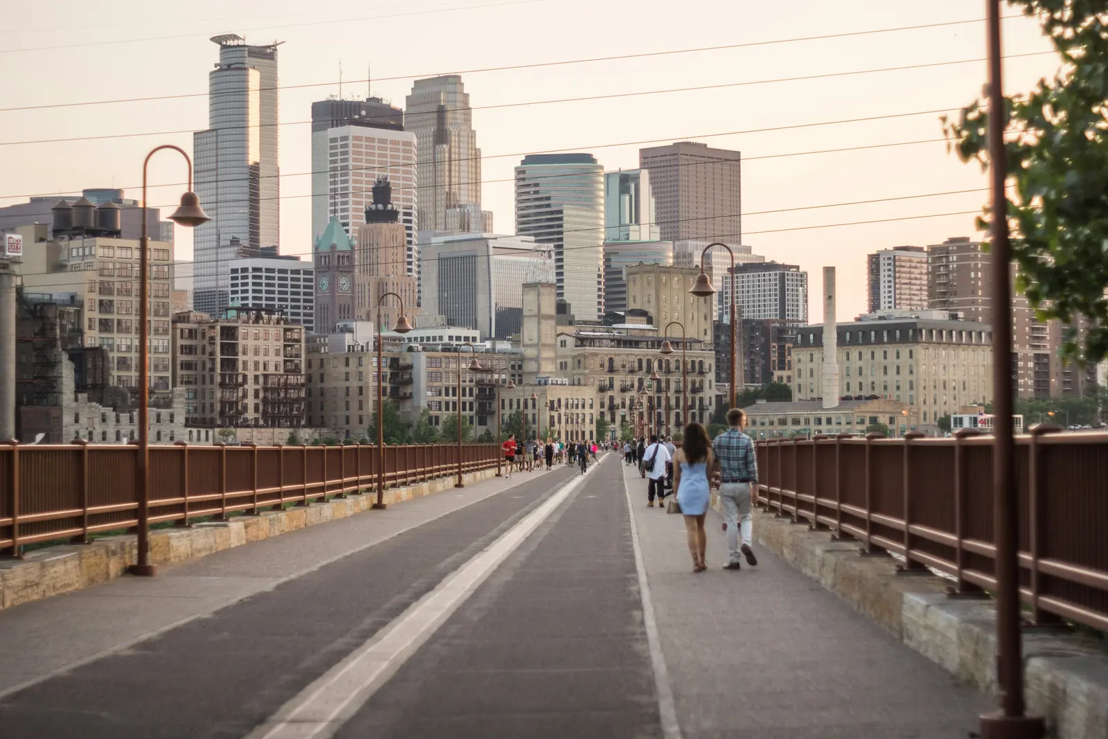 People walking across the Stone Arch Bridge toward downtown Minneapolis